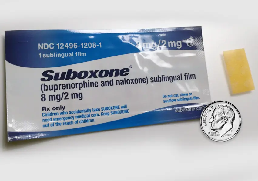A package of suboxone is shown next to a coin.