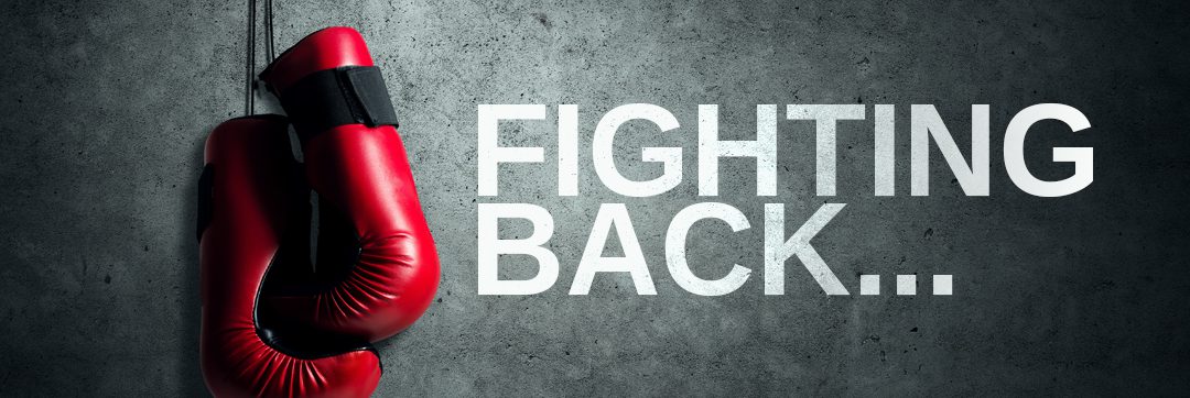 A red boxing glove sitting on top of the floor.