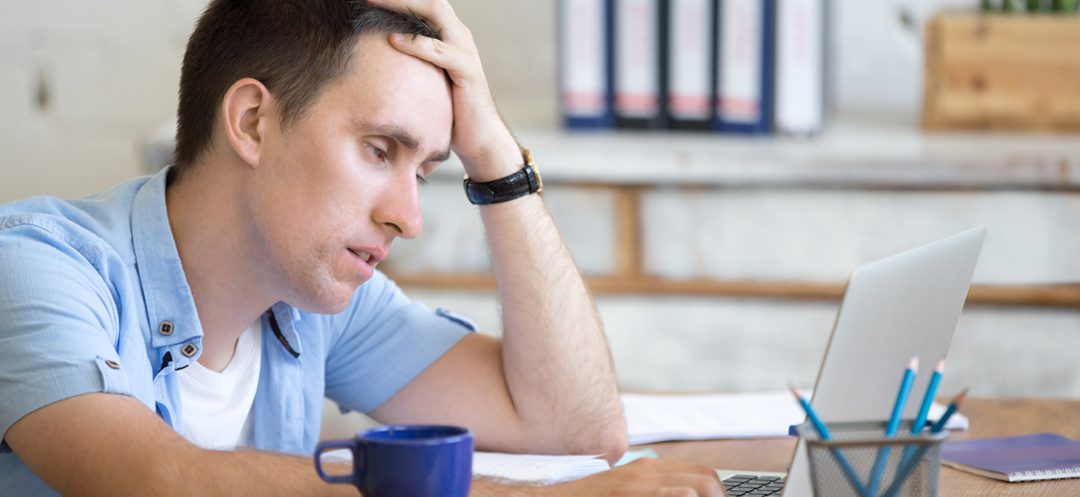 A man sitting at a table with his head on his hand.