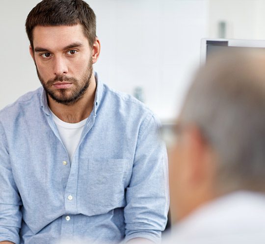 A man sitting in front of another man.