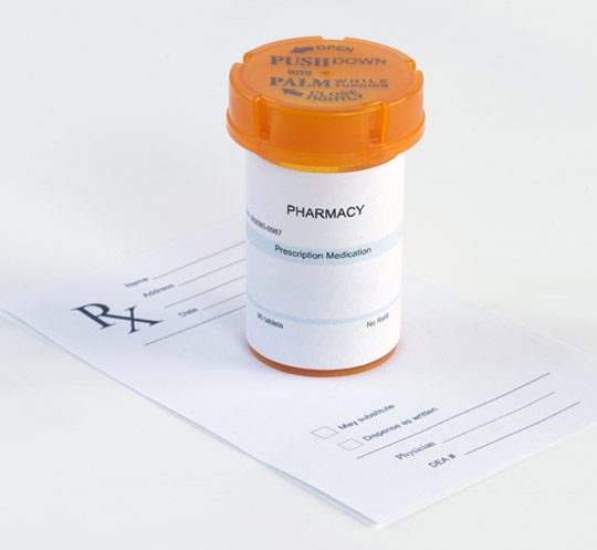 A prescription bottle sitting on top of a paper.