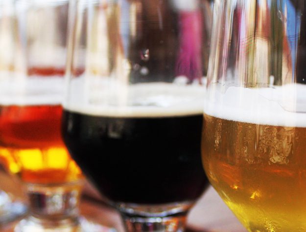 A close up of some glasses with different types of beer.