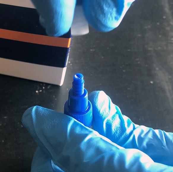 A person in blue gloves holding a marker