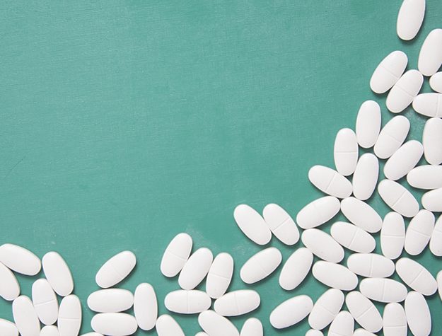 A green table topped with white pills.