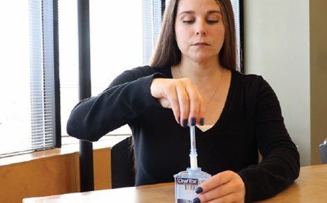 A woman is putting something in her mouth.