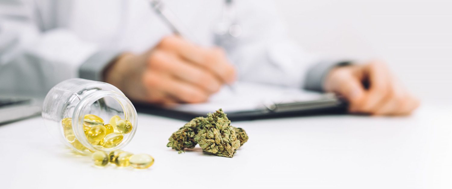 A person sitting at a table with marijuana on it.