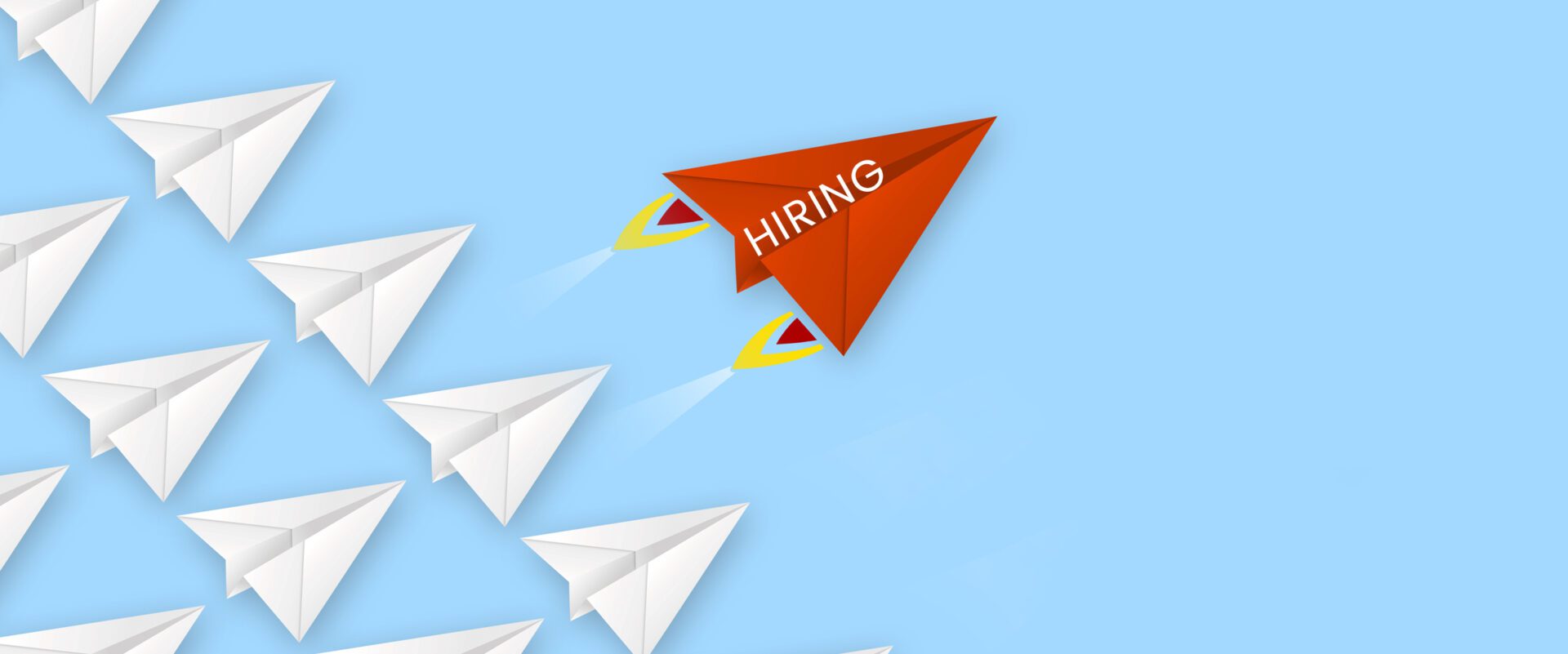 A red kite flying in the sky with " hiring " written on it.