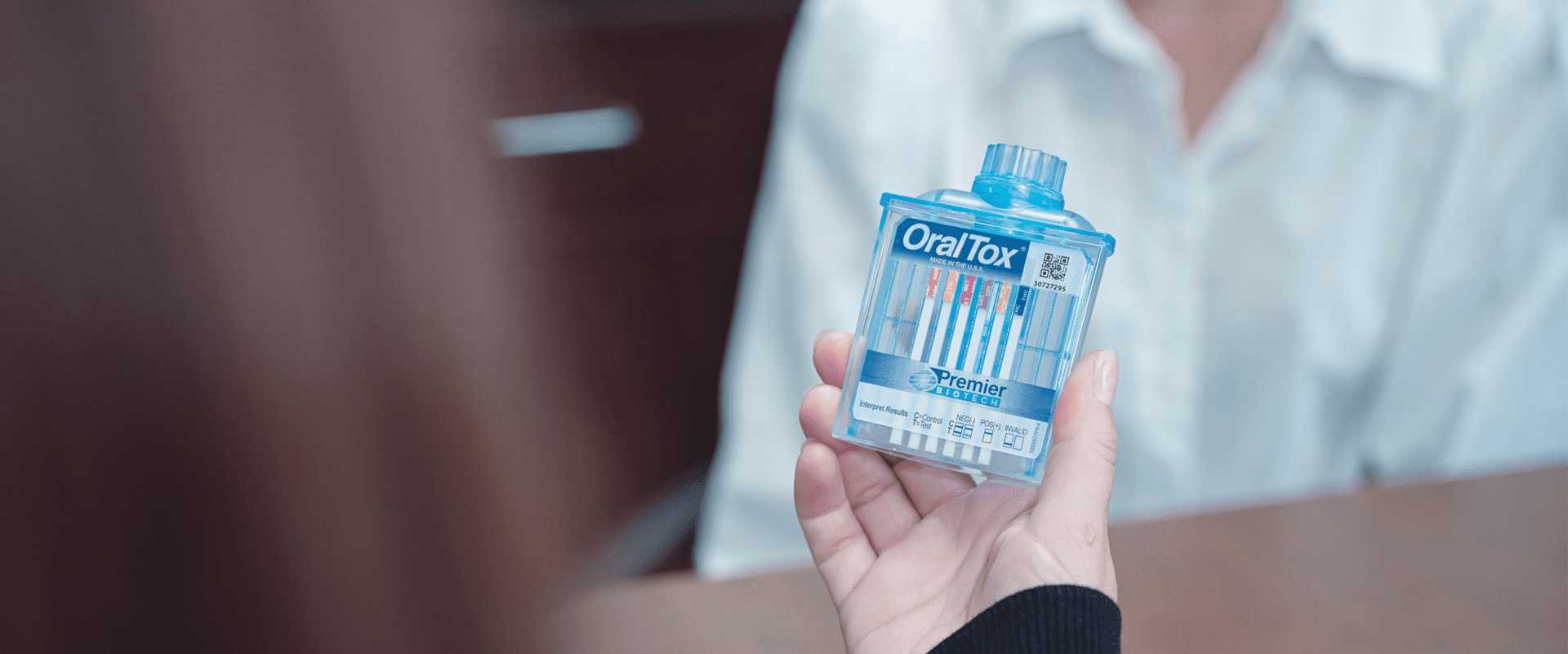 A person holding an oral-b box with tooth brushes in it.