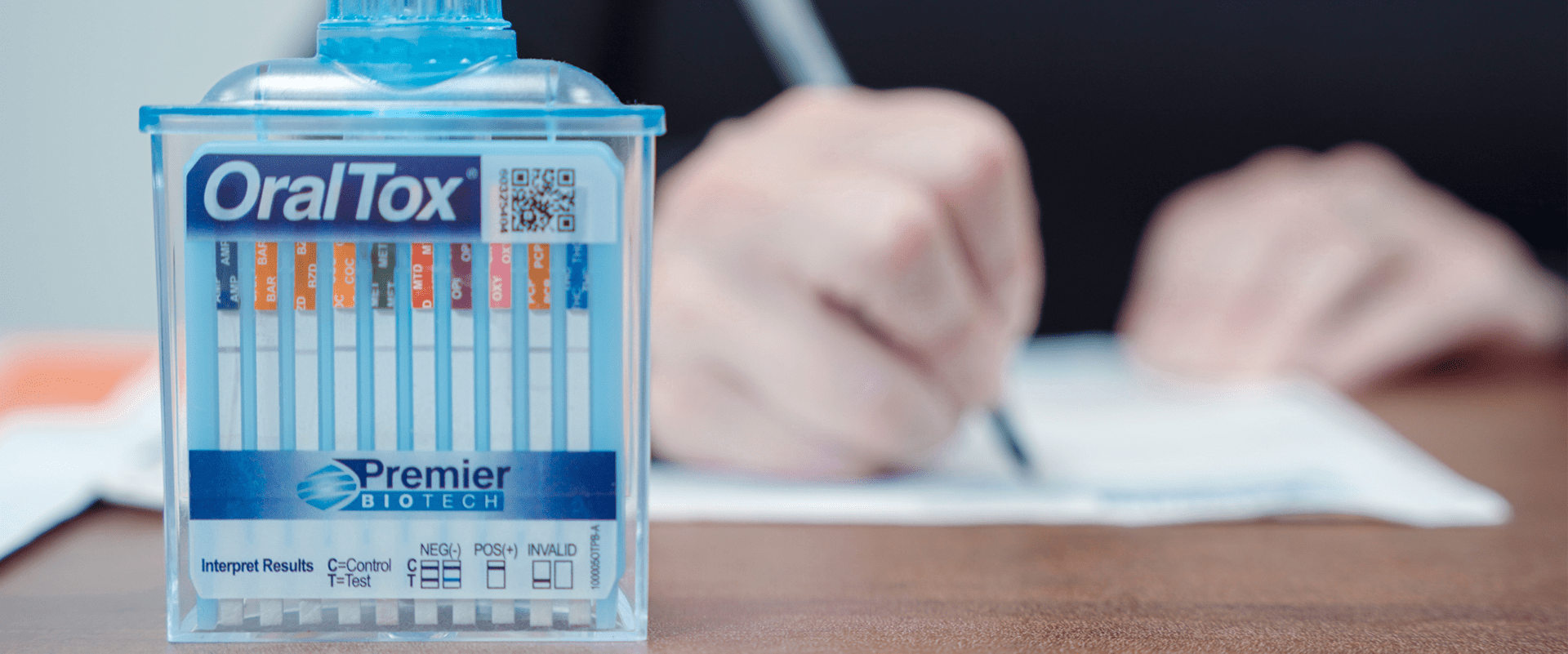 A person writing on paper with a pen and marker.